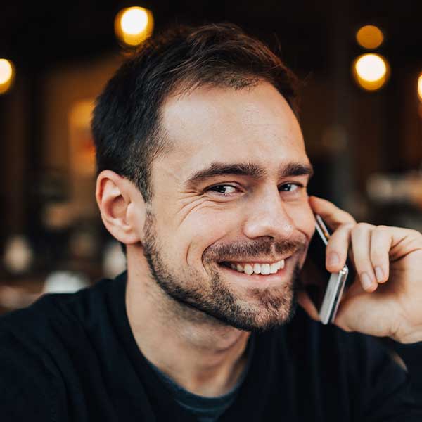 1 Kaboompics Young Smiling Man Using Mobile Phone 4852